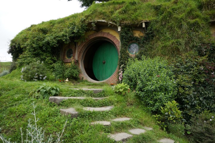 Picture of a hobbit home with a green round door