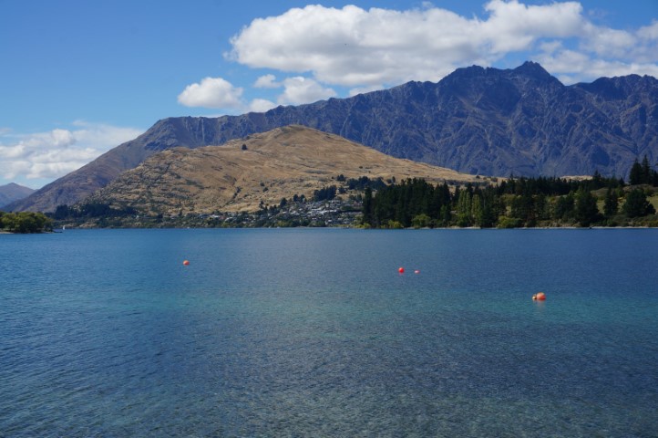 Picture with a view of a hill with a backdrop of a mountain range.