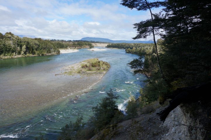 Picture of a river with a delta, banks of smaller rocks and forest